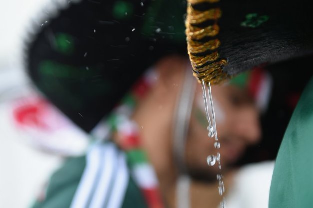 rain-drips-from-a-fans-hat-during-the-mexico-cameroon-game
