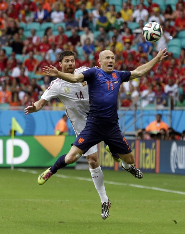 spains-xabi-alonso-and-netherlands-arjen-robben-soar-through-the-air